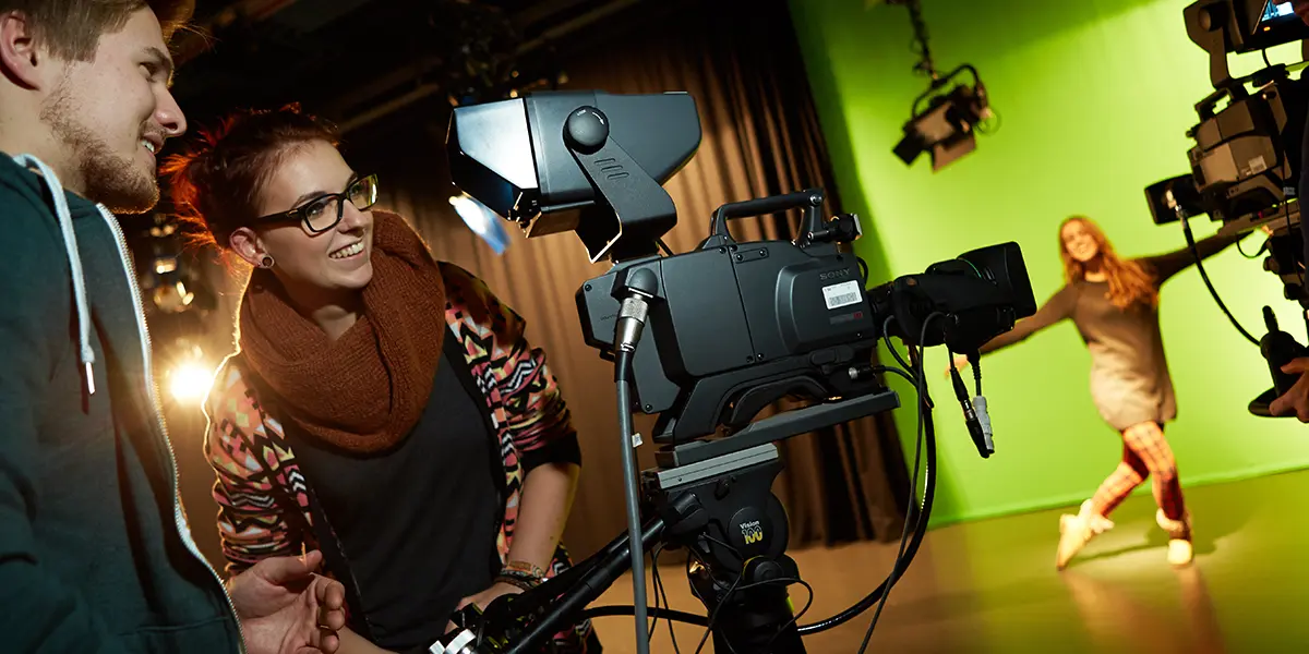 Die Situation zeigt Studierende des Studiengang Motion Picture im Filmstudio, die eine Szene vor einer Greenscreen drehen. Fachbereich Media der h_da, Hochschule Darmstadt.